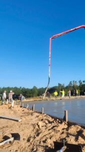 Concrete crew pouring a large slab with a boom pump truck in Cary, NC